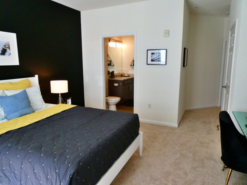 This image shows the bedroom area featuring direct access to the walk-in closet beside.