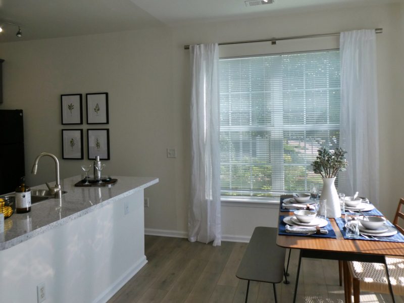 This image shows the Premium Apartment Featuring the dining room area showcasing the simple experience with a minimal dining set and contemporary interior design. The dining area was accessible to the kitchen island.