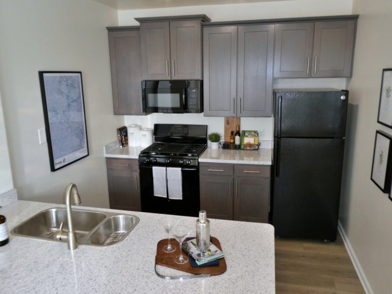 This image shows the premium apartment feature, especially the kitchen island showcasing a neat granite-inspired countertop and an area that has an accessible piece of equipment.