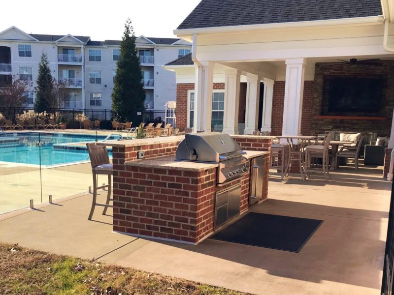 This image shows the outdoor kitchen, featuring the grilling area and lounge area with a swimming pool on the side. This area was ideal during water fun experience.